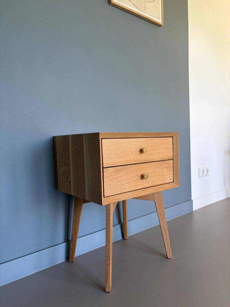 Houten nachtkastje met twee laden, schuin van opzij
